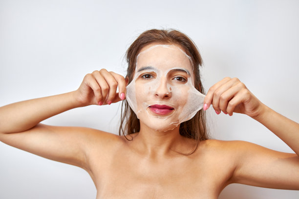 一个女孩用面膜做面部护理。美容理念，护肤化妆品，整容。美容院。去除皱纹。图片下载