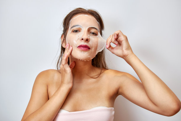 一个女孩用面膜做面部护理。美容理念，护肤化妆品，整容。美容院。去除皱纹。图片下载