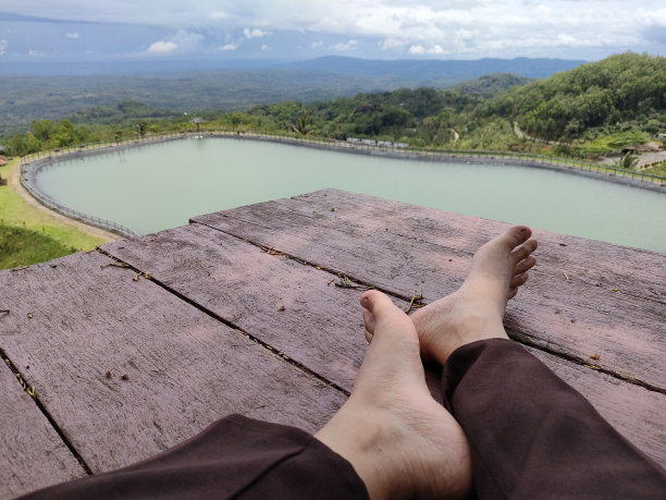 身体部分——脚放在老木头上，面朝风景图片下载
