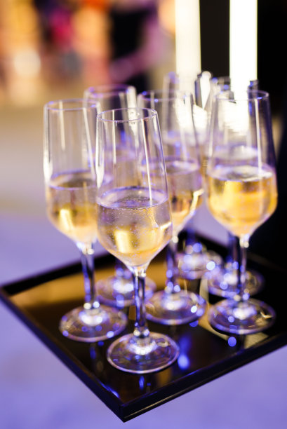 服务员拿着黑色托盘和香槟杯，起泡白葡萄酒图片下载