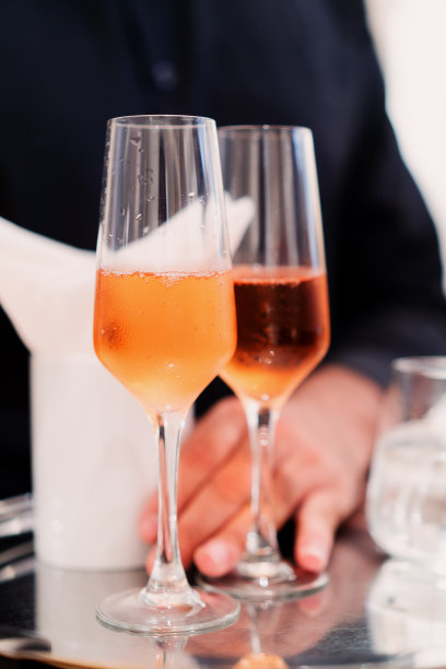 服务生在不锈钢托盘上用香槟长笛杯盛鸡尾酒图片下载