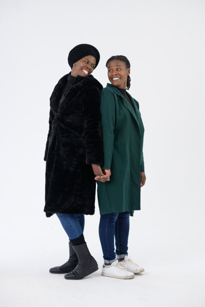 两个非洲妇女在一起的工作室肖像背靠背站着微笑图片下载