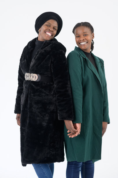 两个非洲女人一起站在摄影棚的肖像背靠背看着相机微笑图片下载