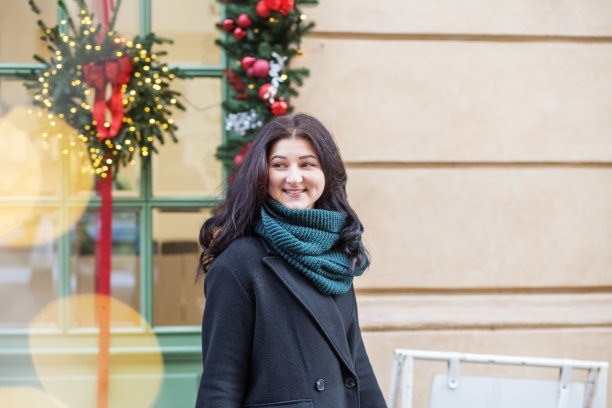一名年轻女子在圣诞节期间周游欧洲。寒冷的天气和温暖的针织围巾。图片下载