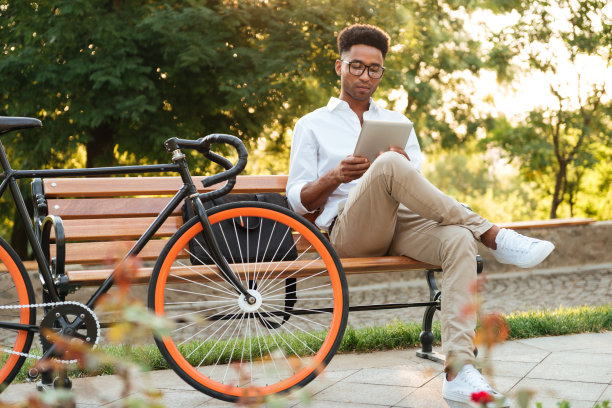 英俊的非洲青年使用平板电脑。图片下载