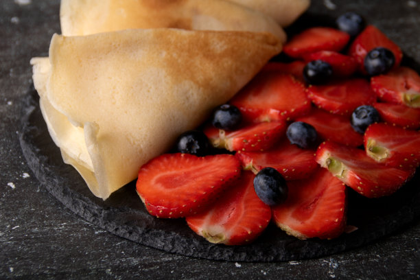 草莓、蓝莓和薄煎饼放在盘子里的照片图片下载