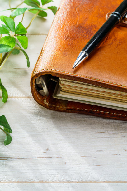 木桌上的环形记事本和笔图片下载