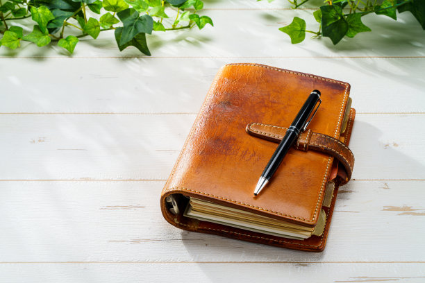 木桌上的环形记事本和笔图片下载