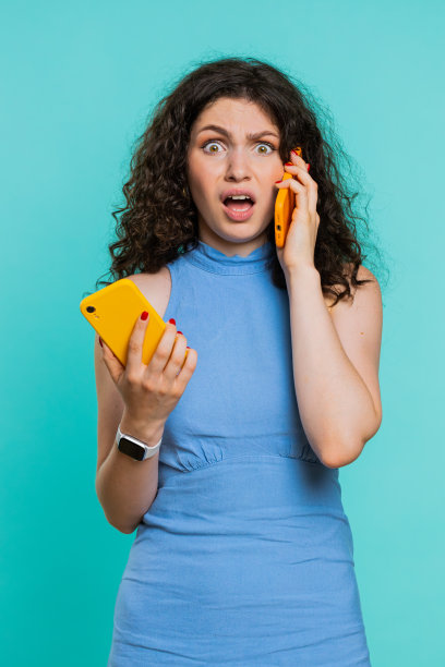 心烦意乱的女商人一边讲着两部手机，一边发生谈话冲突争吵图片下载