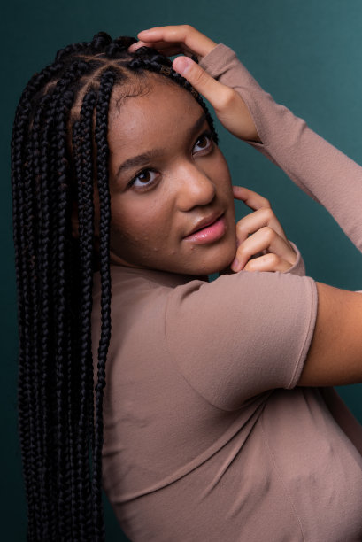 美丽的年轻女子的肖像，双手放在头上。辫子。图片下载