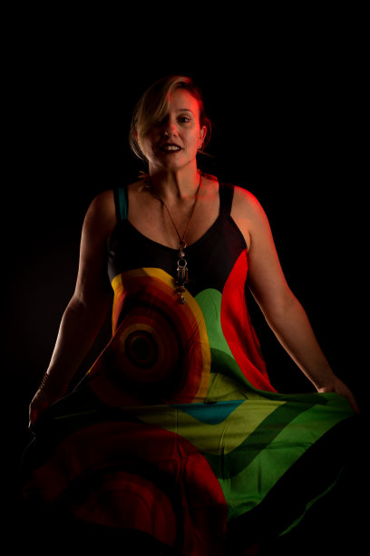 漂亮的白人女人站在那里，穿着五颜六色的衣服。图片下载