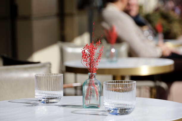 街边咖啡馆，花瓶里的装饰品，户外桌子上的两个空杯子图片下载