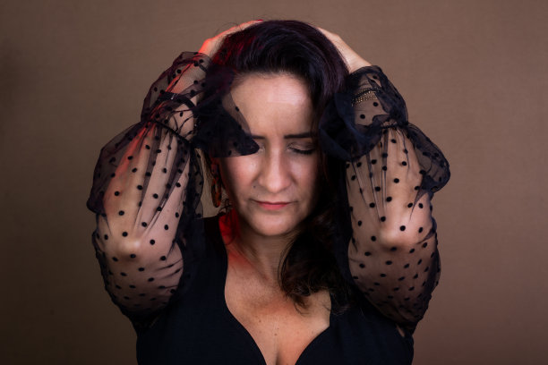 教练女士穿着黑色衣服，双手放在脑后，表示关心。图片下载