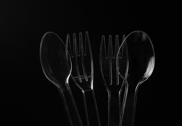 透明塑料勺子和叉子在黑色背景图片下载