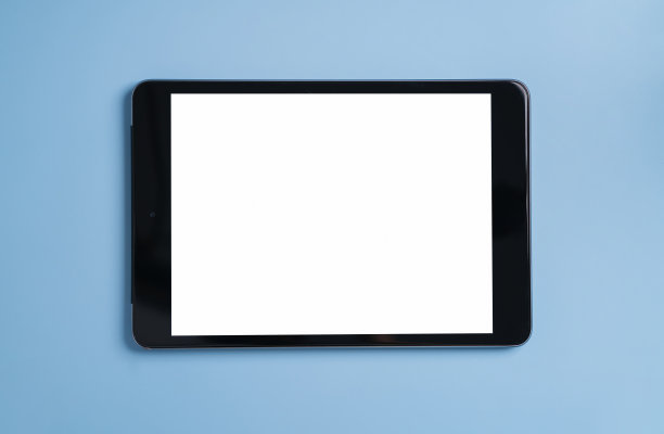 黑色平板电脑的顶视图与蓝色背景上的空白屏幕。图片下载