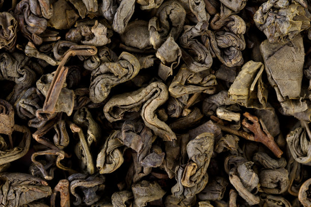 乌龙茶中鸟嘌呤呈圆形分离。绿茶背景。白色背景上分离的干绿茶叶子图片下载