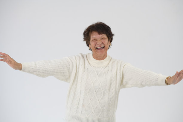 快乐笑老年女子工作室肖像手臂举起图片下载