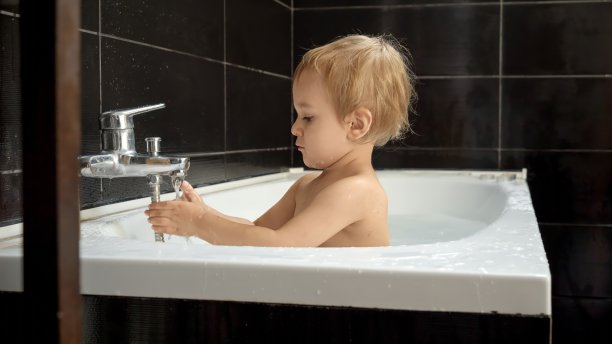 男婴享受洗澡时间，玩水和泡沫玩得很开心。保持婴儿的清洁和健康图片下载