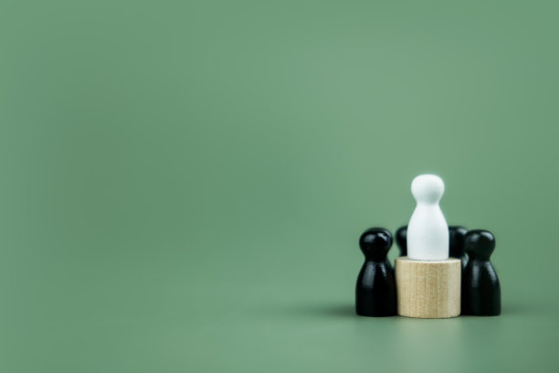 白色木栓娃娃站在讲台上，黑色木栓娃娃站在地上。赢家的概念。图片下载