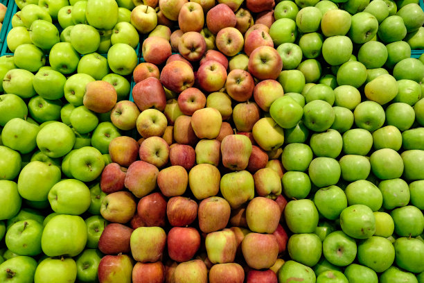 商店柜台上的绿苹果和红苹果。图片下载