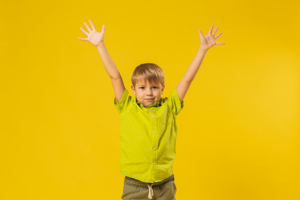 黄色背景下工作室里穿衬衫的男孩图片下载