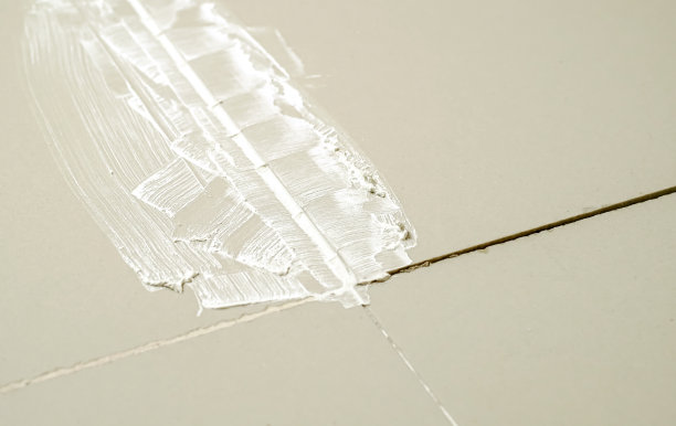 地面灰色瓷砖之间用浆料灌浆缝。前后对比。特写镜头。图片下载