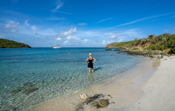 在美属维尔京群岛的热带加勒比海圣约翰岛上，一名女子正在享受美丽幽静的盐池海滩图片下载