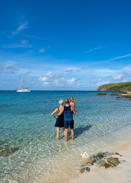 在美属维尔京群岛的热带加勒比海圣约翰岛上，母亲、父亲和女儿正在享受美丽幽静的盐池海滩图片下载