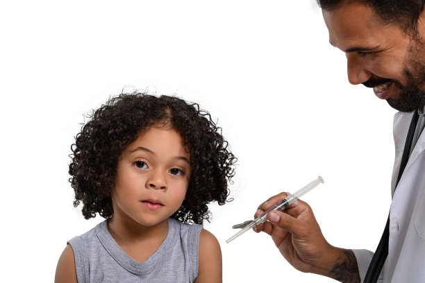 一名卫生工作者在手臂上给一个孩子接种疫苗，这个男人拿着注射器微笑，孩子看着相机，孤立在白色的背景下图片下载