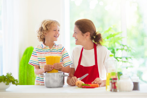 家庭烹饪晚餐妈妈和孩子做意大利面图片下载