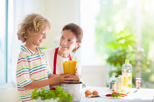 家庭烹饪晚餐妈妈和孩子做意大利面图片下载