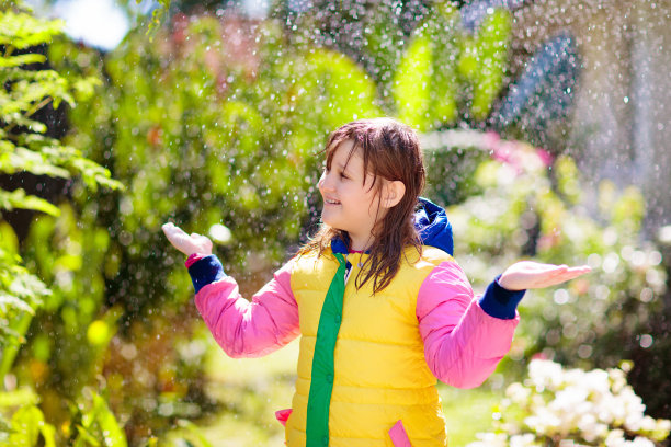 孩子在秋雨中玩耍。拿着伞的孩子。图片下载