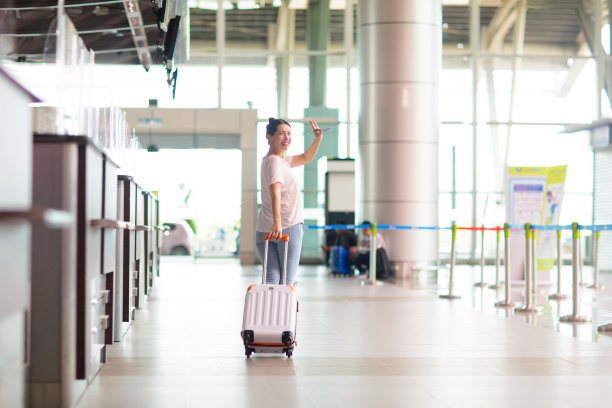 年轻的亚洲女人在机场。乘飞机旅行。图片下载