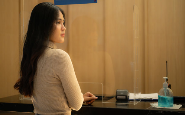 年轻女子在售票处前预订电影票图片下载