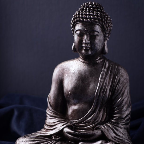 冥想佛像在黑暗的背景。关闭了。副本的空间。图片下载