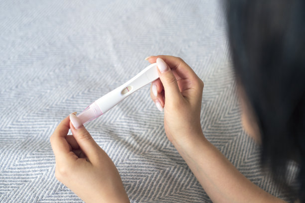 躺在床上的沮丧的年轻女子。验孕阴性的女孩。手和装备的特写图片下载