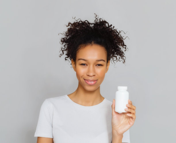 快乐的女人拿着一瓶膳食补充剂或维生素健康的生活方式图片下载