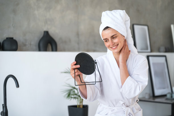 微笑的女人看着镜子里的自己的肖像图片下载