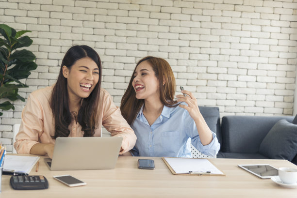 两个亚洲女性自由职业者阅读财务图表策划分析市场数据。亚洲人团队办公公司。两个女商人在公司办公桌上用笔记本电脑开会。图片下载