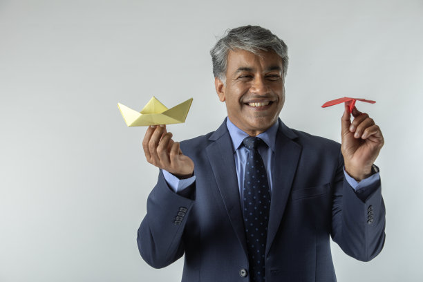 微笑的商人拿着折纸站在白色的背景上图片下载