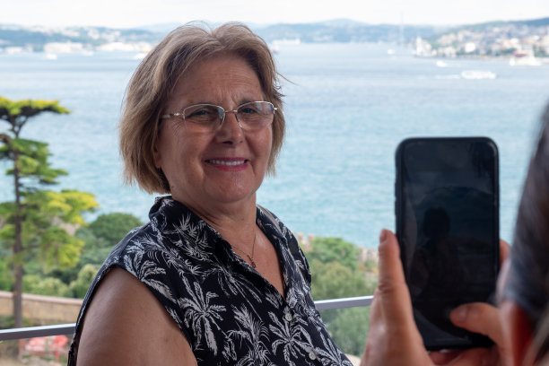 捕捉记忆:在托普卡帕宫阳台上，一位年长的女游客用智能手机拍摄的照片图片下载