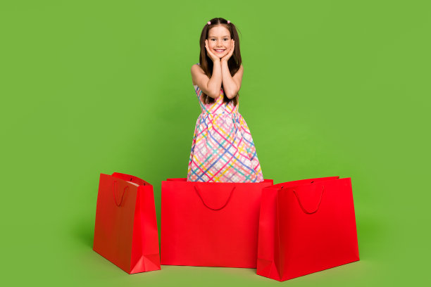 可爱的快乐的女孩穿着时髦的衣服，买低价衣服孤立的绿色背景的全身照片图片下载