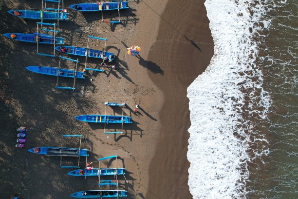 蓝色的渔船停泊在岸边。印度尼西亚是世界上最大的海洋国家，从海洋中捕捞了大量的鱼类。kapal nelayan pantai Pangandaran。海岸鸟瞰图。图片下载