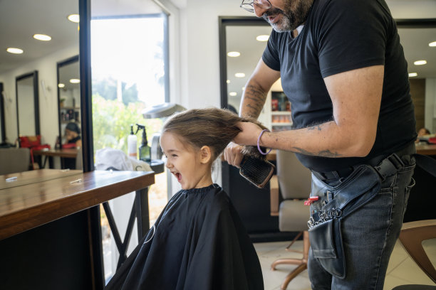 快乐的小女孩在理发店理发和梳头图片下载