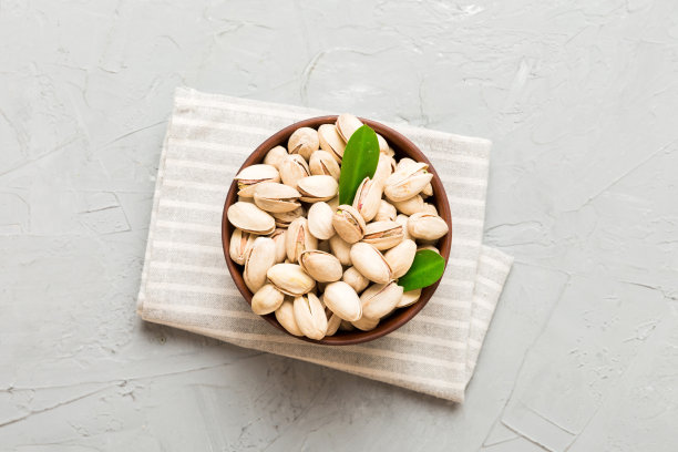 新鲜健康的开心果在碗在彩色的桌子背景。健康饮食理念。超级食物图片下载