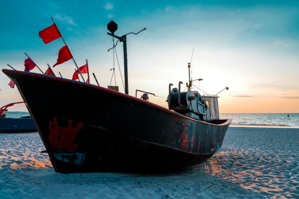 波兰波罗的海海滩上的日落。波兰Międzyzdroje附近傍晚的渔船。图片下载