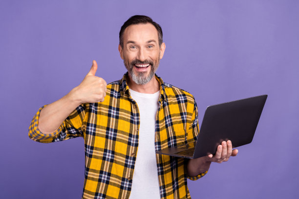 照片的满意开朗的大胡子男子穿着格子衬衫推荐现代科技商店提供销售孤立的紫色背景图片下载