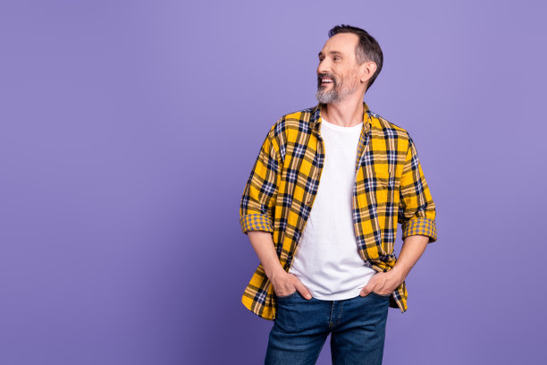 照片的好男人与白色灰色的胡子穿黄色格子衬衫手臂在口袋里看起来空的空间销售孤立的紫色背景图片下载