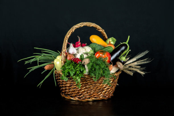 蔬菜放在柳条篮子里，烹饪各种菜肴的食材放在黑色的背景上图片下载