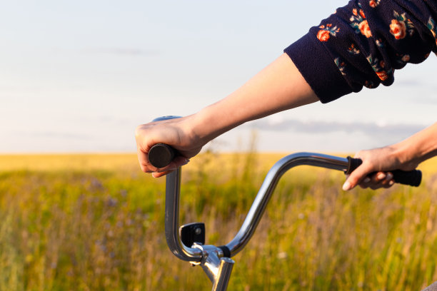 握着自行车把手的手。图片下载